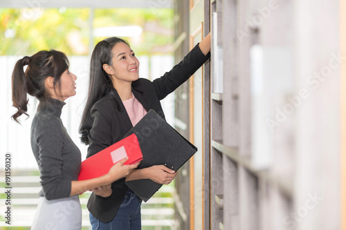 Secretary and Purchasing Manager Helping to sort out company files and Filing account file in a modern Office shelves room. Set up studio shooting.