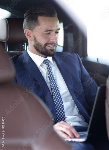 Portrait of a business man in the back seat of a car © ASDF