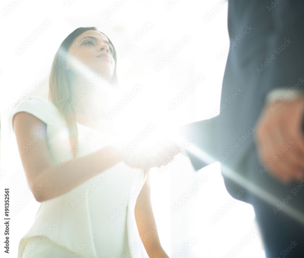 Naklejka premium Beautiful businesswoman shaking hand with her partner