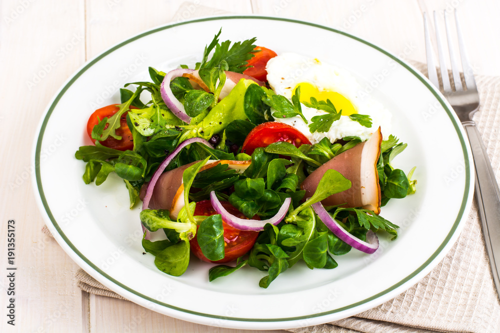 Fresh vegetable salad with ham and fried egg