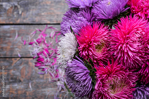 Fototapeta Naklejka Na Ścianę i Meble -  Aster flowers bouquet purple red pink white on a wooden background. selective focus