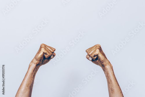 Golden female hands with fists