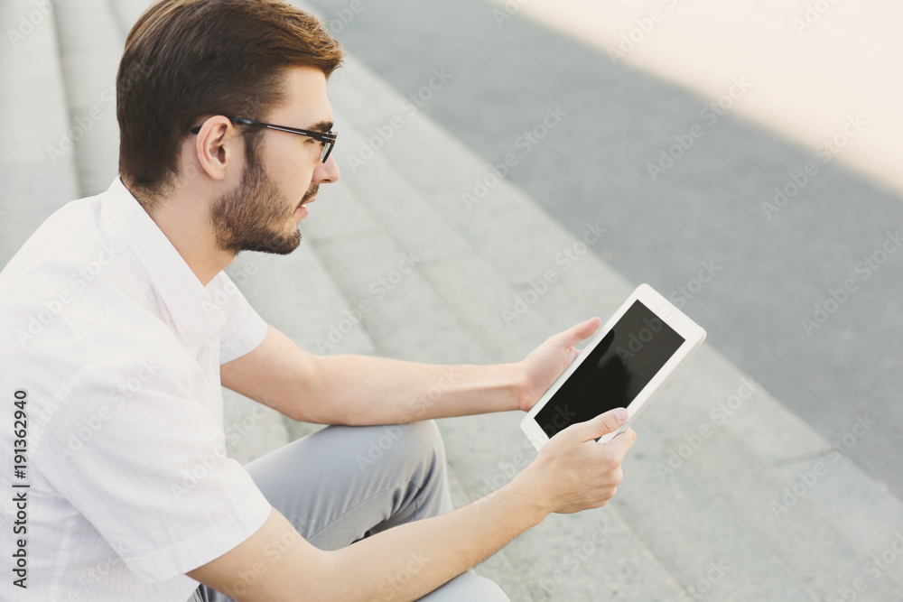 Pensive businessman working with tablet outdoors Pensive businessman working with tablet outdoors