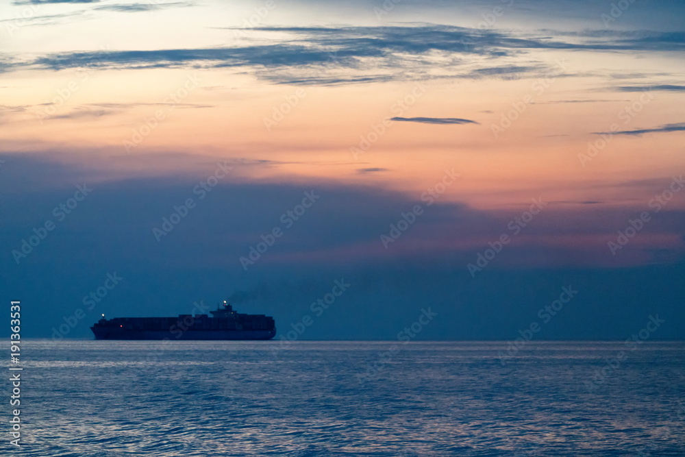 Container ship sail along the trade route in the evening before sunset