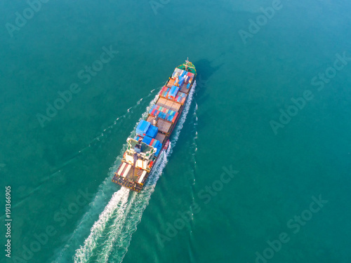 Container ship in export and import business and logistics. Shipping cargo to harbor by crane. Water transport International. Aerial view © MAGNIFIER