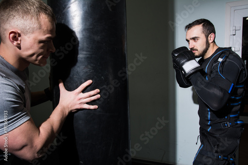 Strong man in boxing gloves during training. © kanzefar