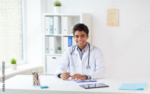 happy doctor with clipboard at clinic