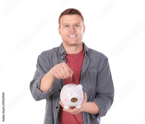 Young man putting coin into...
