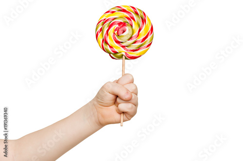 Child's hand holding big colorful lollipop