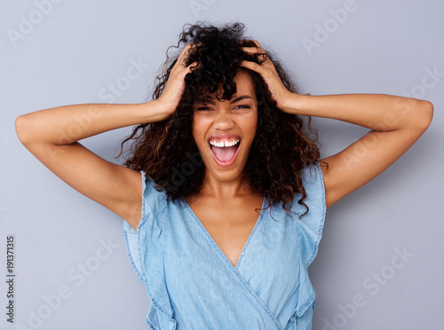 young african american woman shouting with hand in hair