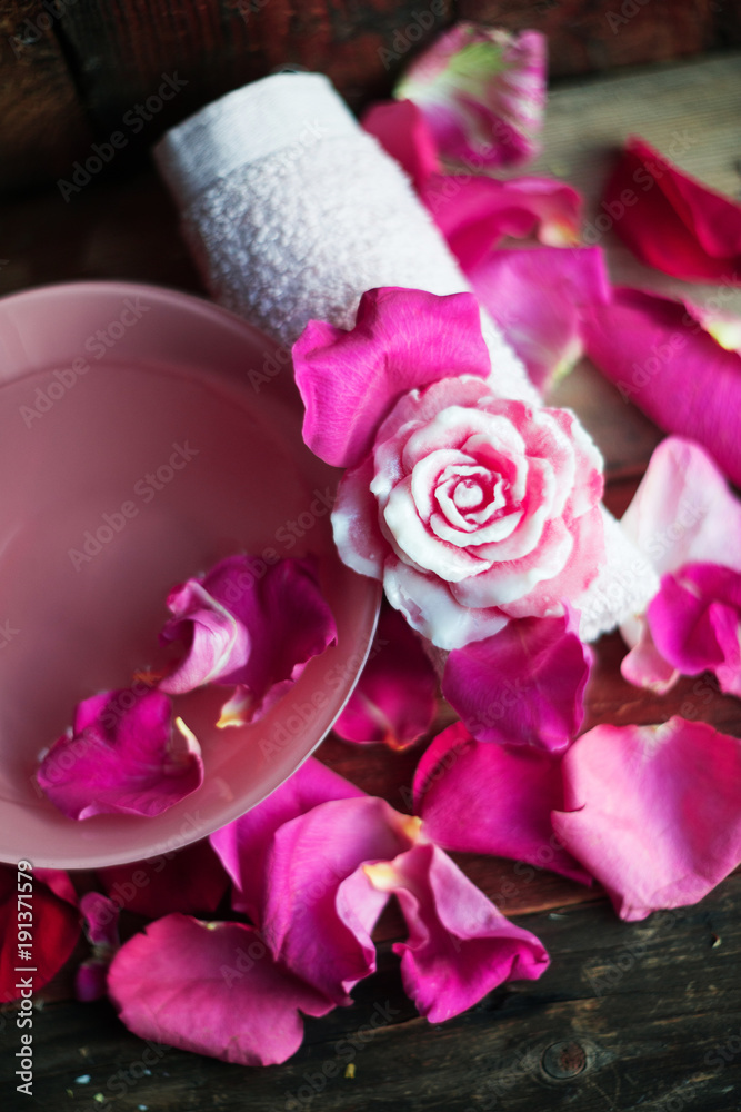 Bowl with water and rose petals on wooden table Bowl with water and rose petals on wooden table