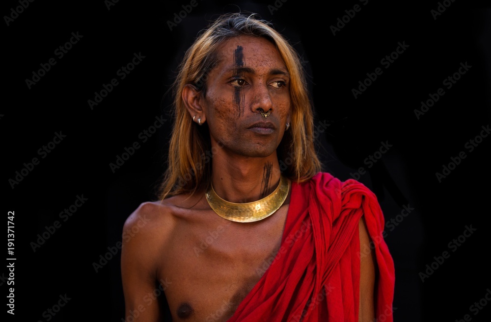 South Indian Tamil man in traditional red toga and golden ornaments