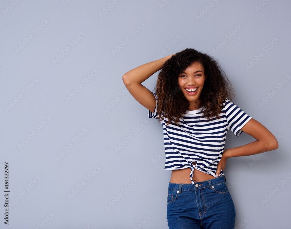 cheerful young black woman laughing against gray background cheerful young black woman laughing against gray background