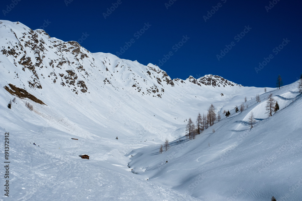 Tief verschneites Tal in Osttirol unter blauem Himmel