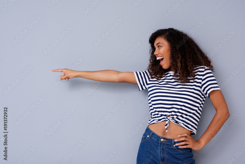 happy young woman laughing and pointing at copy space happy young woman laughing and pointing at copy space