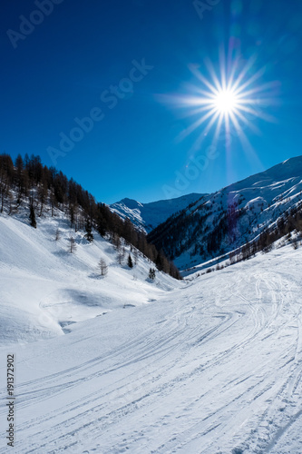 Sonnenschein und blauer Himmel über einem tiefverschneiten Tal in Osttirol