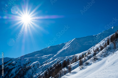 Sonnenschein über einem verschneiten Tal in den Alpen