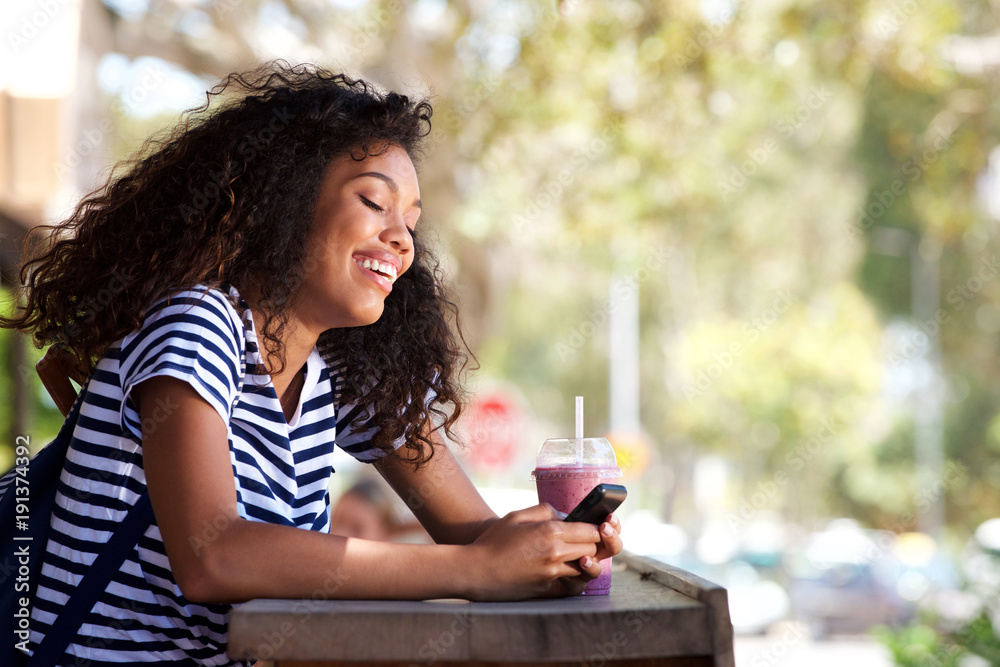 attractive young woman smiling and using mobile phone outside attractive young woman smiling and using mobile phone outside
