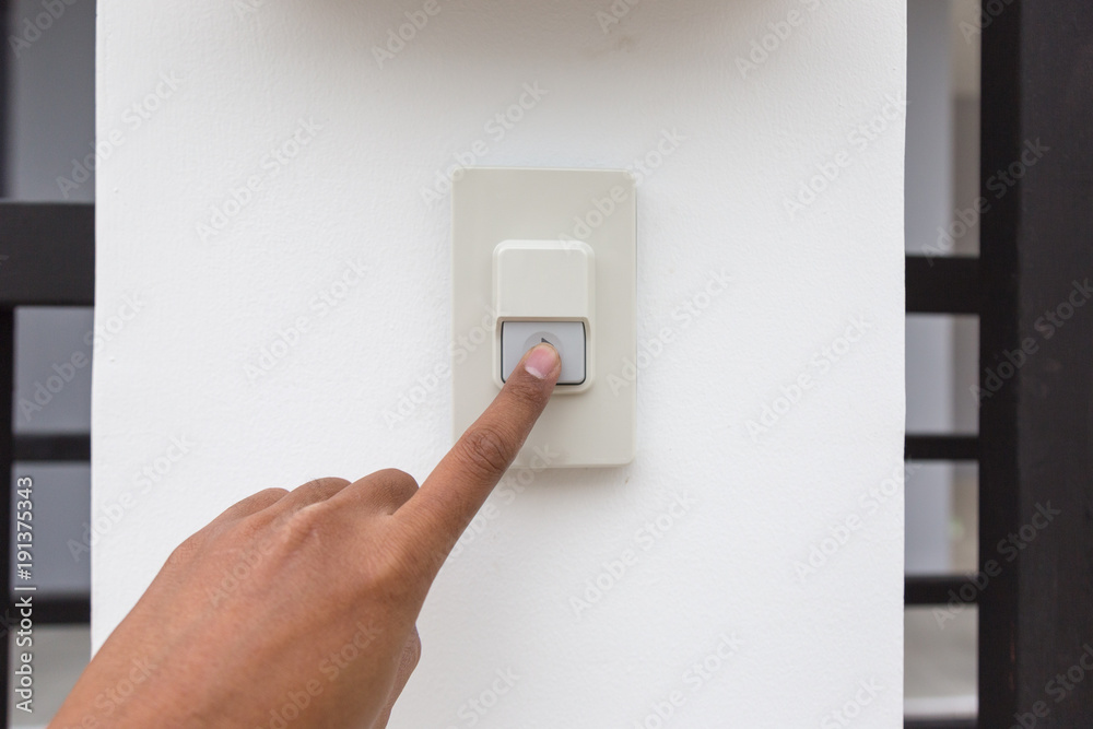 Guest is pressing on ringing bell alarm in front of house. Guest is pressing on ringing bell alarm in front of house.