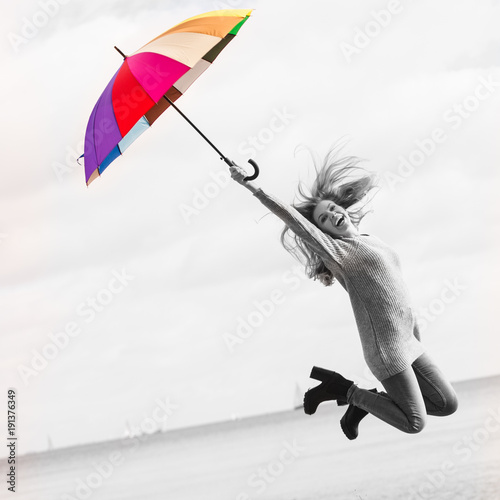 Funny woman jumping with umbrella