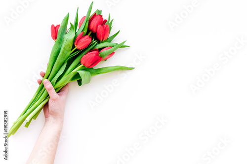 Bright red tulips for spring bouquet on white background top view copy space