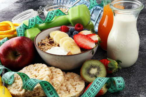 muesli with dairy and fruit, healthy lifestyle. bowl of cereal, fruit and dumbbell