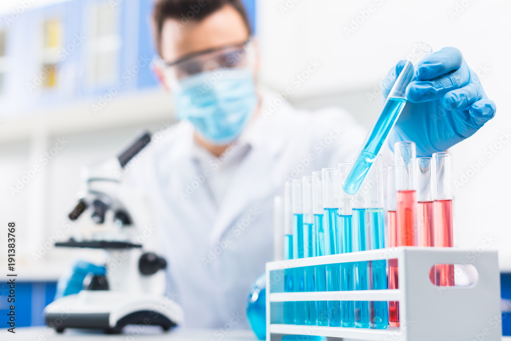 Earnest male lab assistant taking sample Earnest male lab assistant taking sample