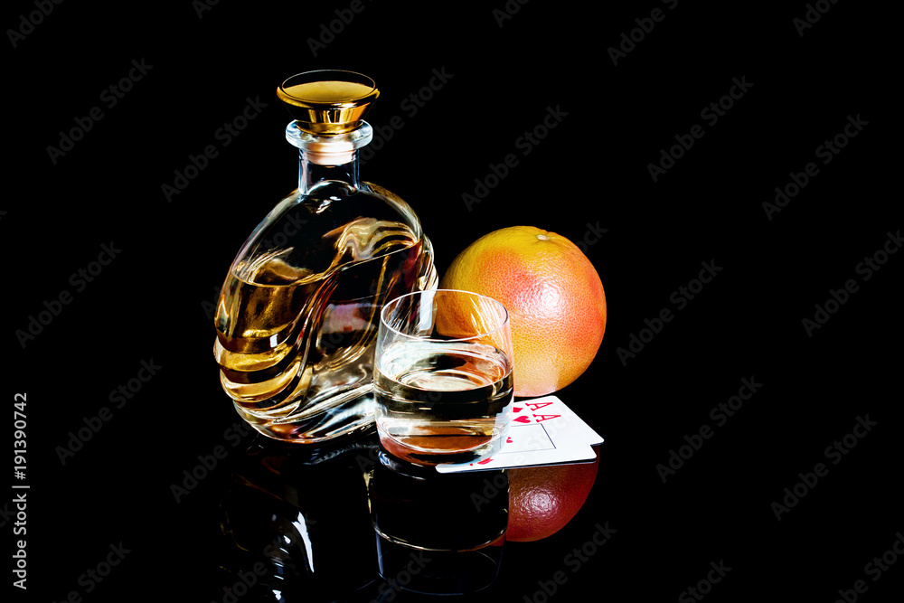 Decanter and glass of whiskey with poker cards on black background Decanter and glass of whiskey with poker cards on black background
