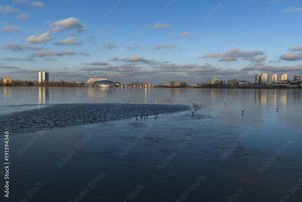 Obraz premium City reflection in a frozen lake on sunset