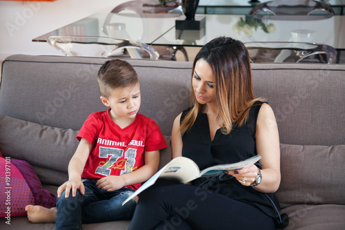Fotografie Mère et son fils lisant un magazine sur le canapé