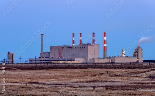 Building of a power plant with smoking pipes and glowing lights