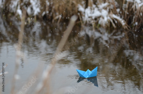 Papierschiffchen mit Schneeflocken im Winter