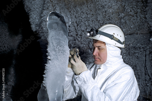 Billede på lærred cave explorer examines the ice stalagmite on the background of a dark rocky wall
