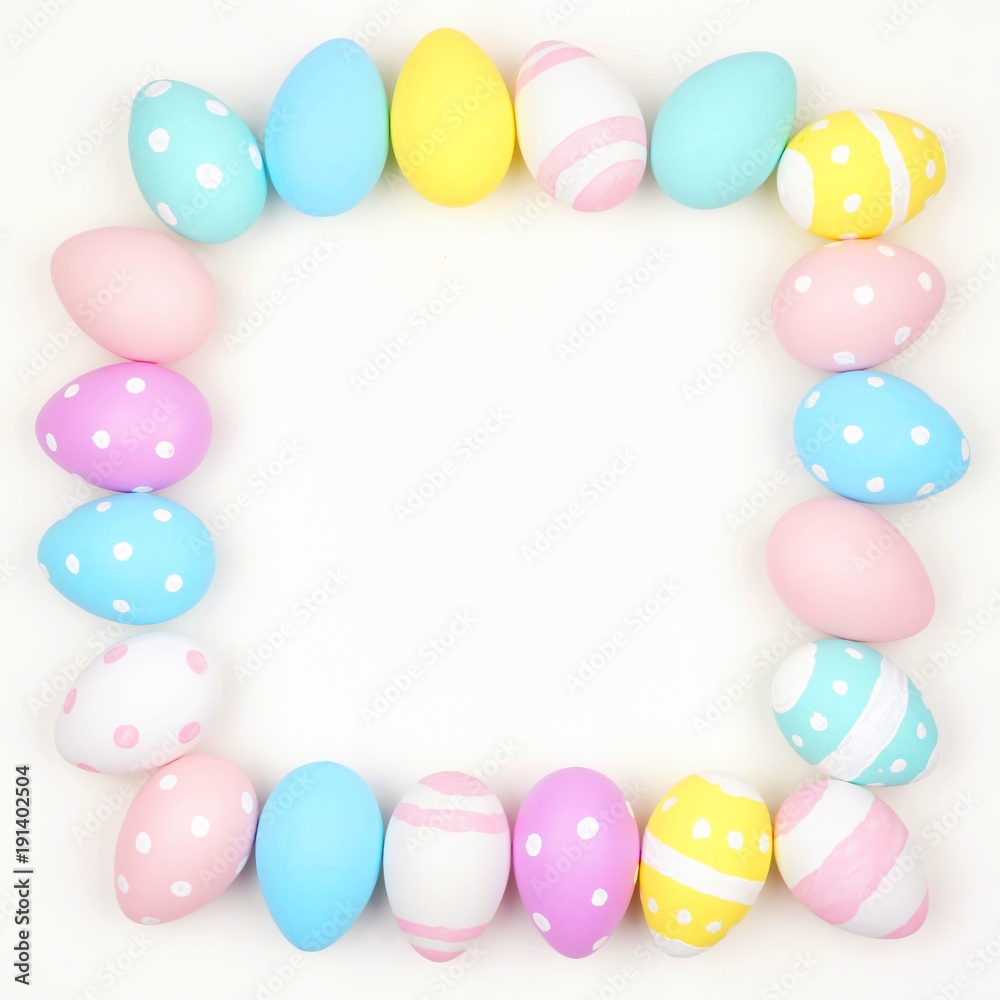 Square frame of pastel colored Easter eggs over a white background