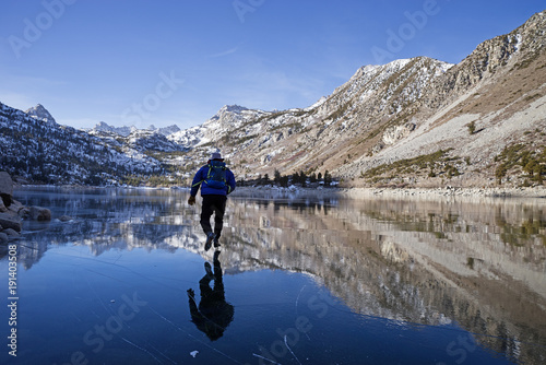 Man Ice Skating On Mountain Lake photo