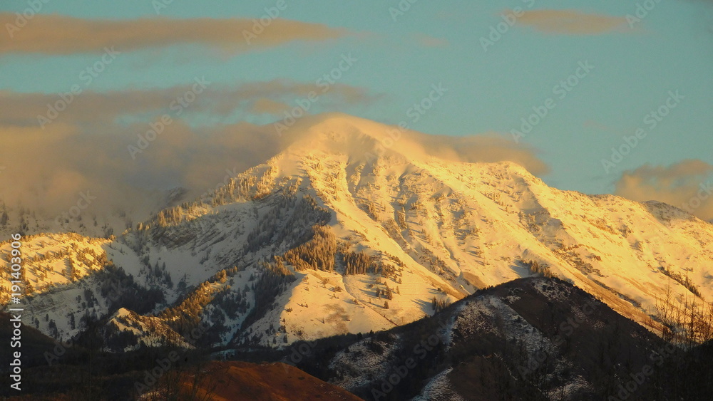 Obraz premium mountain and sky at sunset with clouds and snow in winter