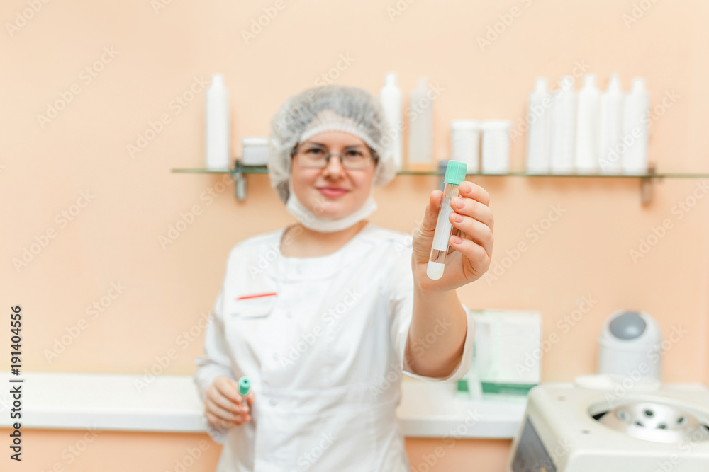 A woman doctor performs tests and analyzes with a beaker in a centrifuge in a cosmetology clinic A woman doctor performs tests and analyzes with a beaker in a centrifuge in a cosmetology clinic