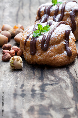 Belgian  chocolate choux buns stuffed with hazelnut cream on wooden table