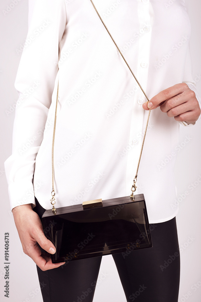 Black Women's handbag in hand, Ladies bag, Black female clutch,Black clutch.Women's bag isolated white background.Bag isolated white background.Clutch isolated white background.