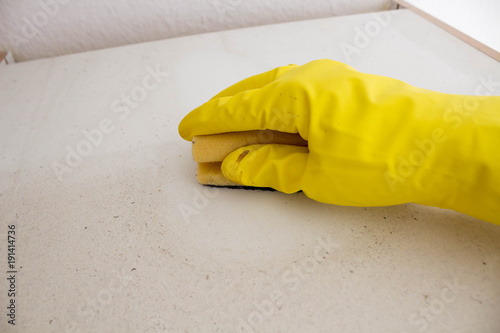 Hand cleanes with a sponge wearing protective gloves