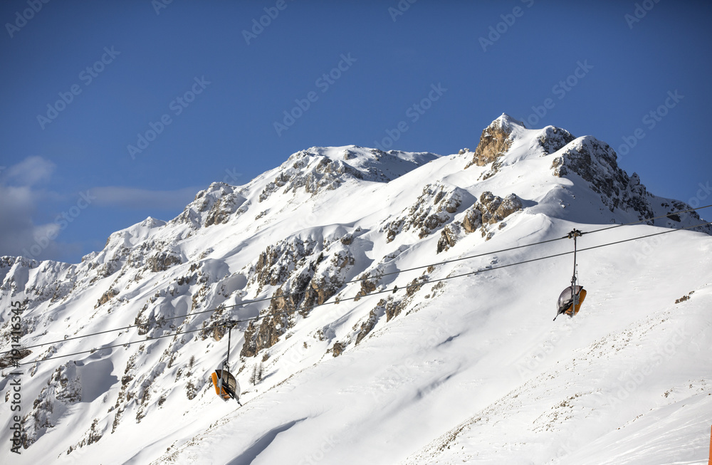 Snow-capped mountains. Alps, winter landscape. Ski resort. Chair lift. Bellamonte, Lusia, Valbona, Dolomites, Italy, Trentino. Winter mountains,panorama - snow-capped peaks of the Italian Alps