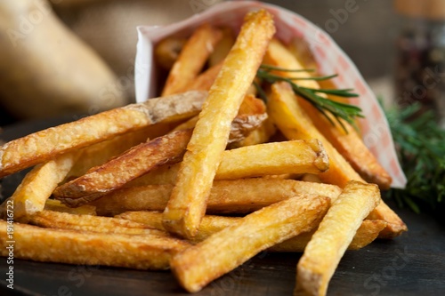 Fast food french fries potatoes with skin served with salt and herbs