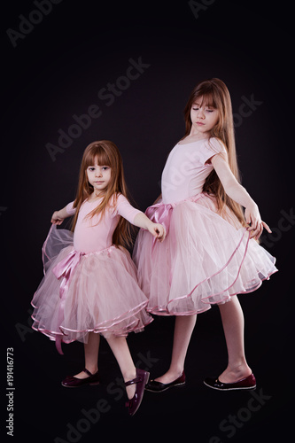 wo girls  sisters in pink dresses with tulle skirts
