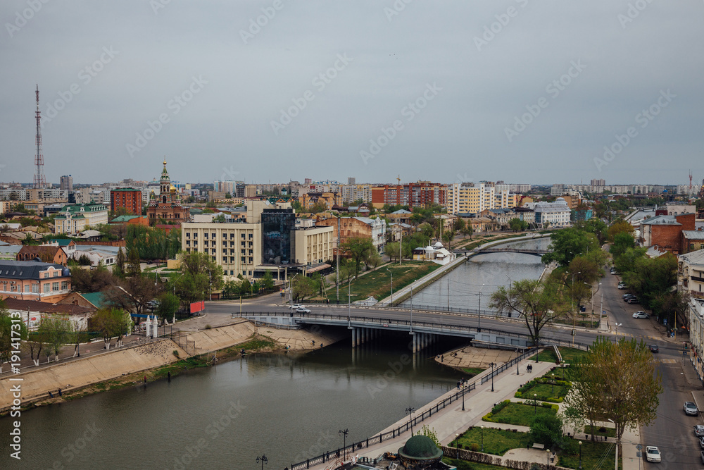 Aerial Astrakhan day cityscape from rooftop. View to bridge through Volga river, historical and modern buildings. Astrakhan downtown