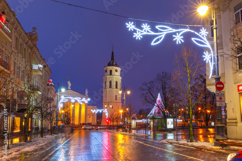 Fototapeta Naklejka Na Ścianę i Meble -  Decorated and illuminated Christmas Gediminas prospect and Cathedral Belfry during evening blue hour, Vilnius, Lithuania, Baltic states.