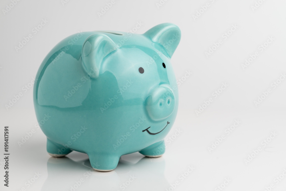 Blue piggy bank on reflection floor and seamless white background