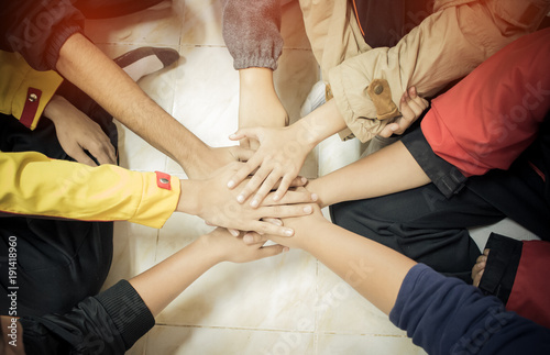 Unity and teamwork Concept: Group of friends hands together. Top view of Asian young people putting their hand together as Friends to stack of hands show teamwork, uninty to activities success in life