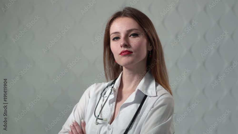 Portrait of a confident female doctor approaching, young and beautiful girl with a stethoscope in the white background Portrait of a confident female doctor approaching, young and beautiful girl with a stethoscope in the white background