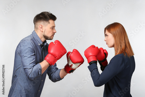 Photos Angry couple in boxing gloves on light background