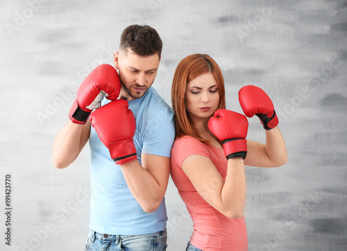 Foto Angry couple in boxing gloves on grey background